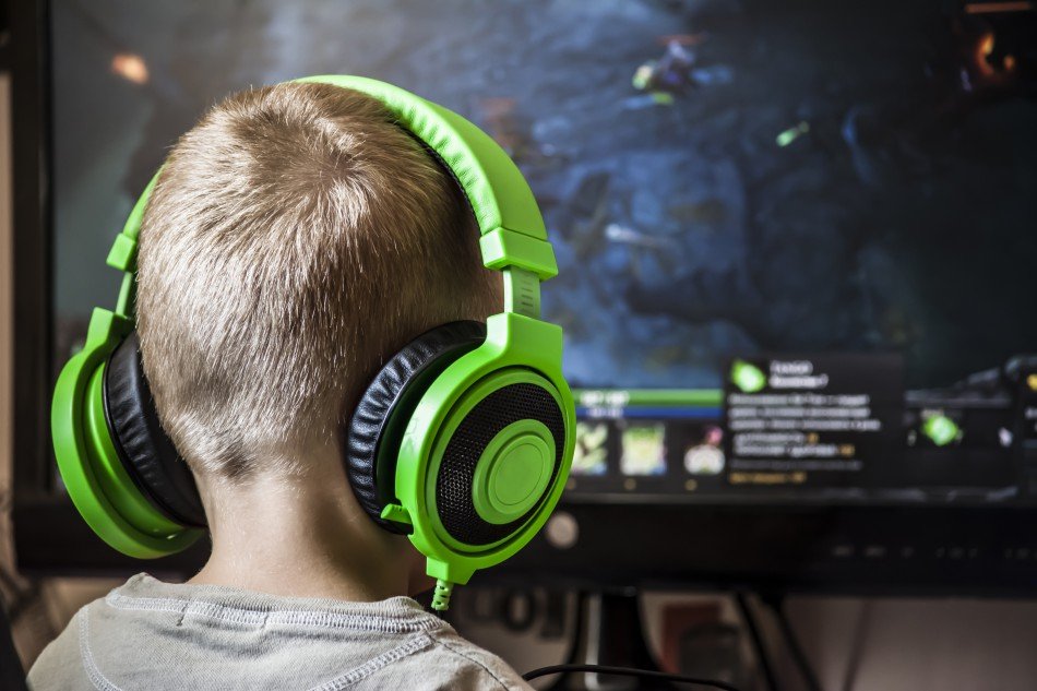 Little boy playing video game with headphones on