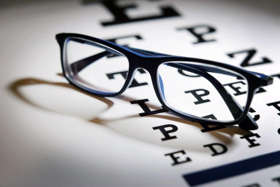 Pair of glasses resting on an optometrist's Letter Screen