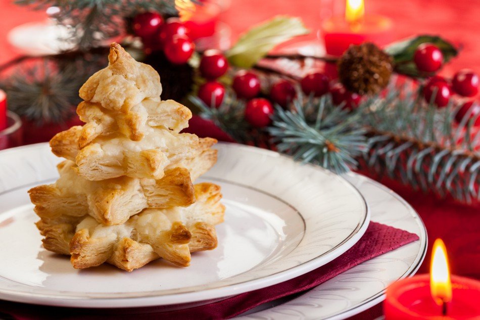 Christmas pastry on plate with holly and pine in background
